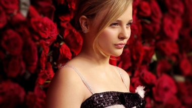 Chloe Moretz and roses in the background Wallpaper