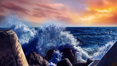 Waves against rocks at sunset Wallpaper