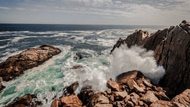 Waves in the sea crashing against rocks Wallpaper