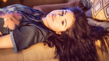 Selena Gomez lying in an armchair Wallpaper