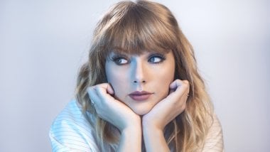 Taylor Swift with her hands on her chin Wallpaper