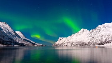 Aurora Borealis in lake and mountains Wallpaper