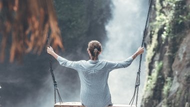 Girl in swing near a waterfall Wallpaper