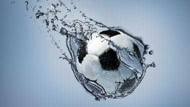 Balón de fútbol atravesando agua Fondo de pantalla
