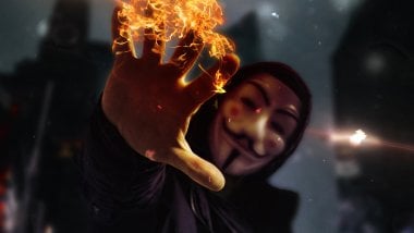 Mascara de Anonimo con mano en fuego Fondo de pantalla