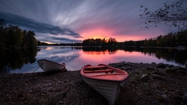 Boat in lake at sunset Wallpaper
