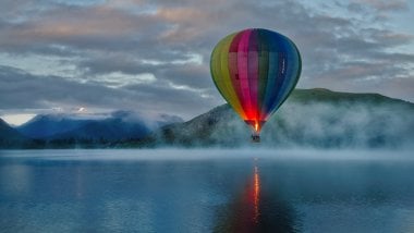 Hot air balloon in lake with mountains Wallpaper