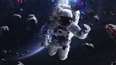 Astronauta flotando alrededor de asteroides Fondo de pantalla
