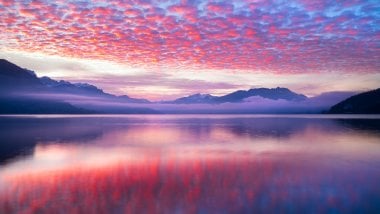 Nubes rosas reflejadas en lago Fondo de pantalla
