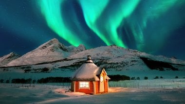 Casa en el invierno con aurora polar en las montañas Fondo de pantalla