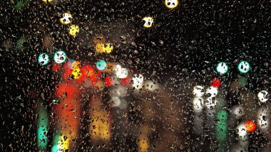 Luces del tráfico a través de vidrio con gotas de lluvia Fondo de pantalla