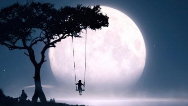 Girl on a swing looking at the moon Wallpaper
