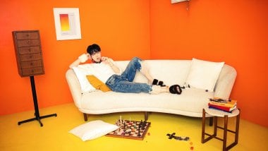 Suga from BTS laying down on couch Wallpaper