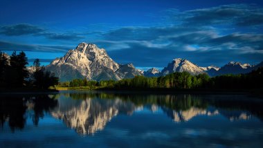 Mountains reflected in lake with blue sky Wallpaper