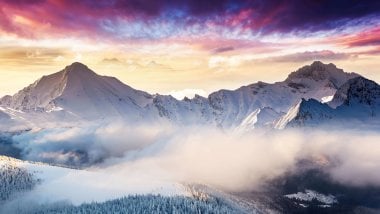 Purple sunset in snowy mountains Wallpaper