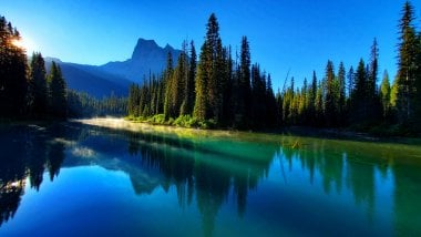 Montañas a través de lago y árboles en Canada Fondo de pantalla
