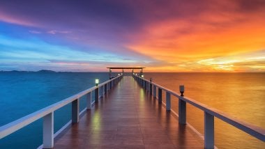 Wooden pier in front of the sea at sunset Wallpaper
