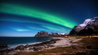 Aurora polar en las  montañas frente al mar Fondo de pantalla