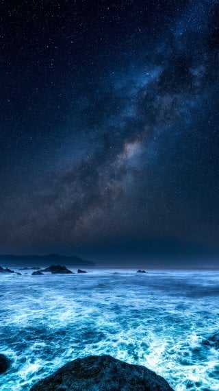 Bioluminescent Ocean Waves at Night under the Milky Way Wallpaper
