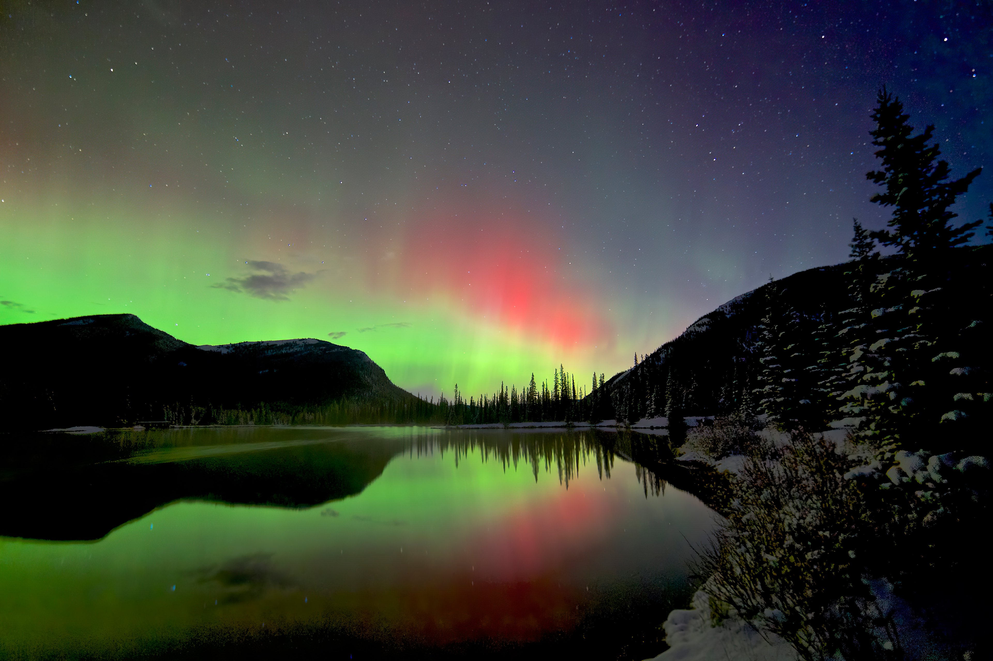 Fondos de pantalla Northern lights behind mountains and lake