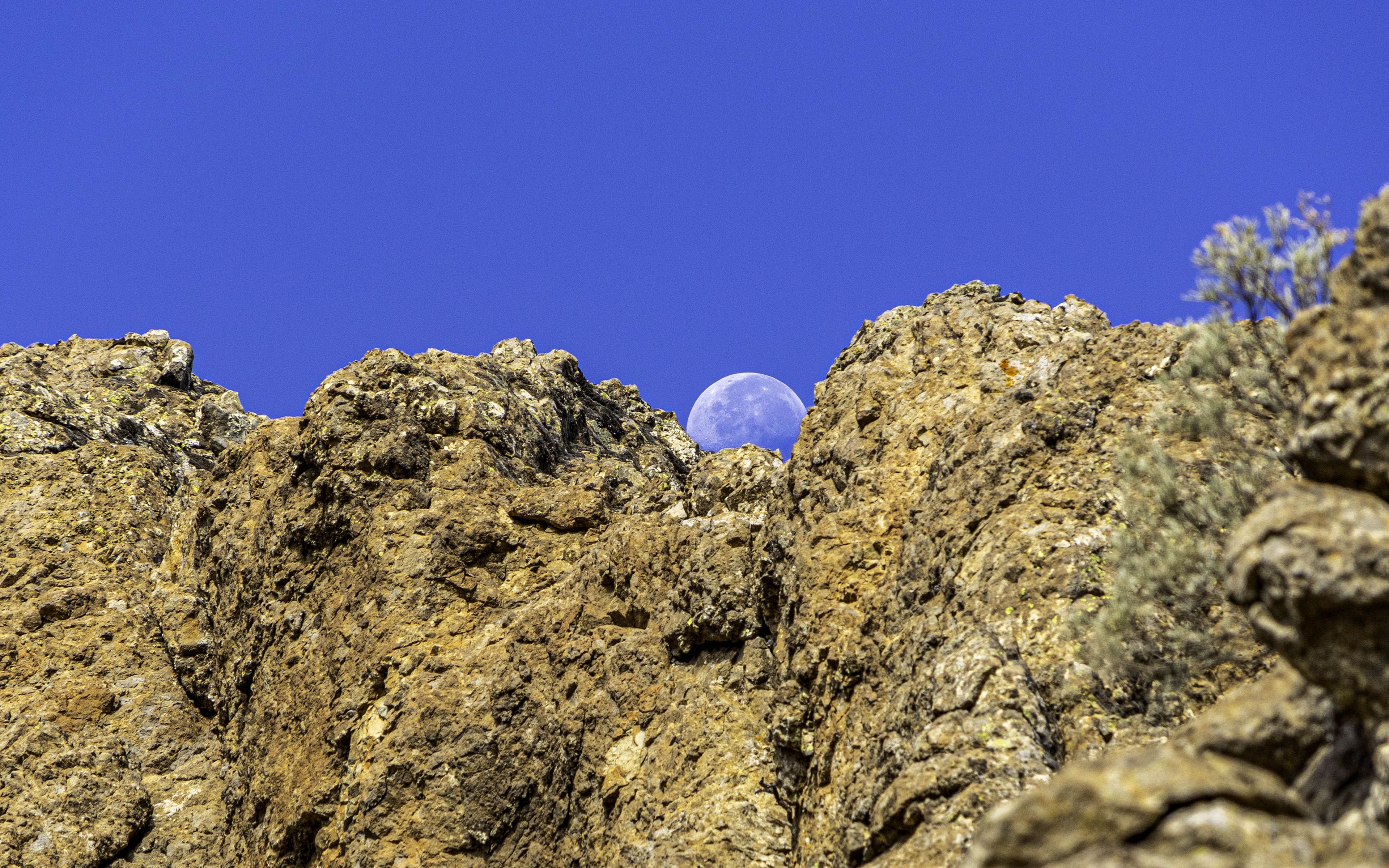 Fondos de pantalla Luna detrás de rocas
