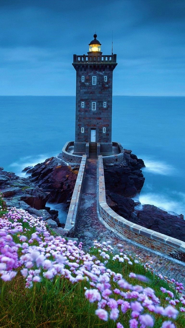 Wallpaper Lighthouse at the sea with flowers Vertical