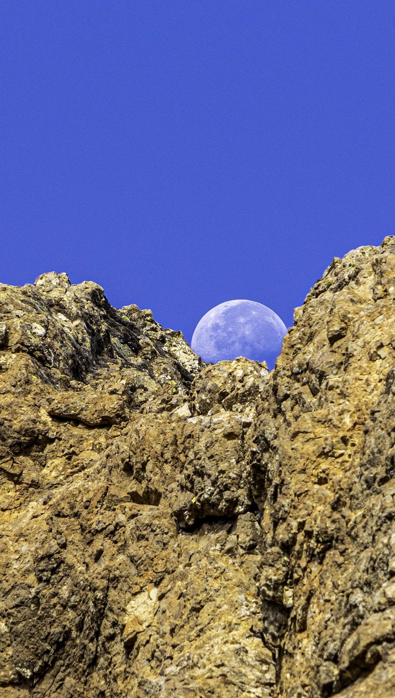 Fondos de pantalla Luna detrás de rocas Vertical
